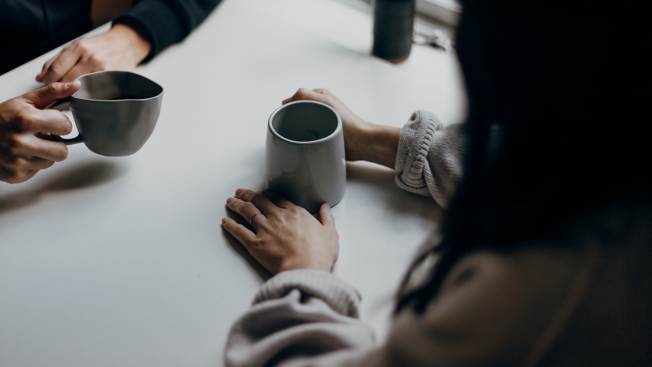 Reunión cara a cara con un cliente tomando un café