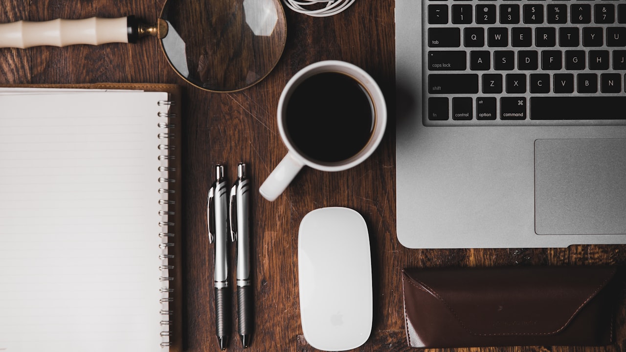 Escritorio prolijo con café, cuaderno y laptop