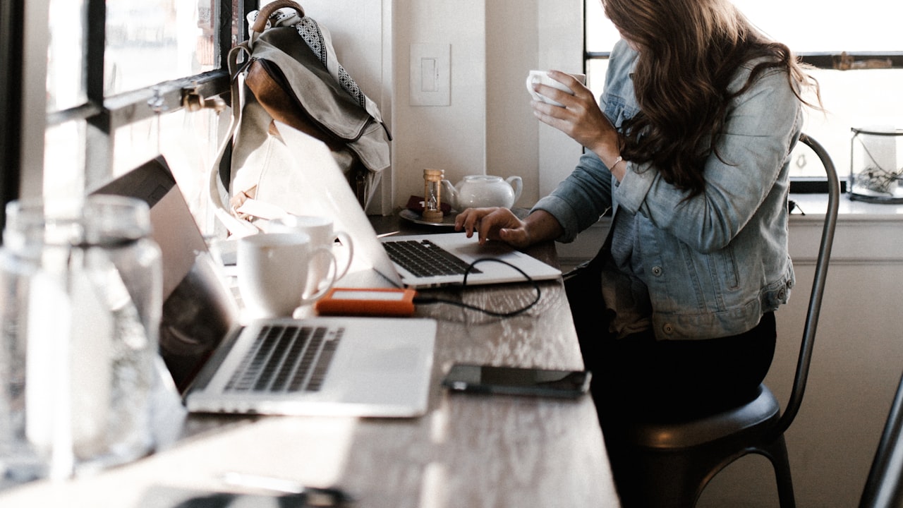 Persona trabajando tranquila con un café mientras el día sigue su curso