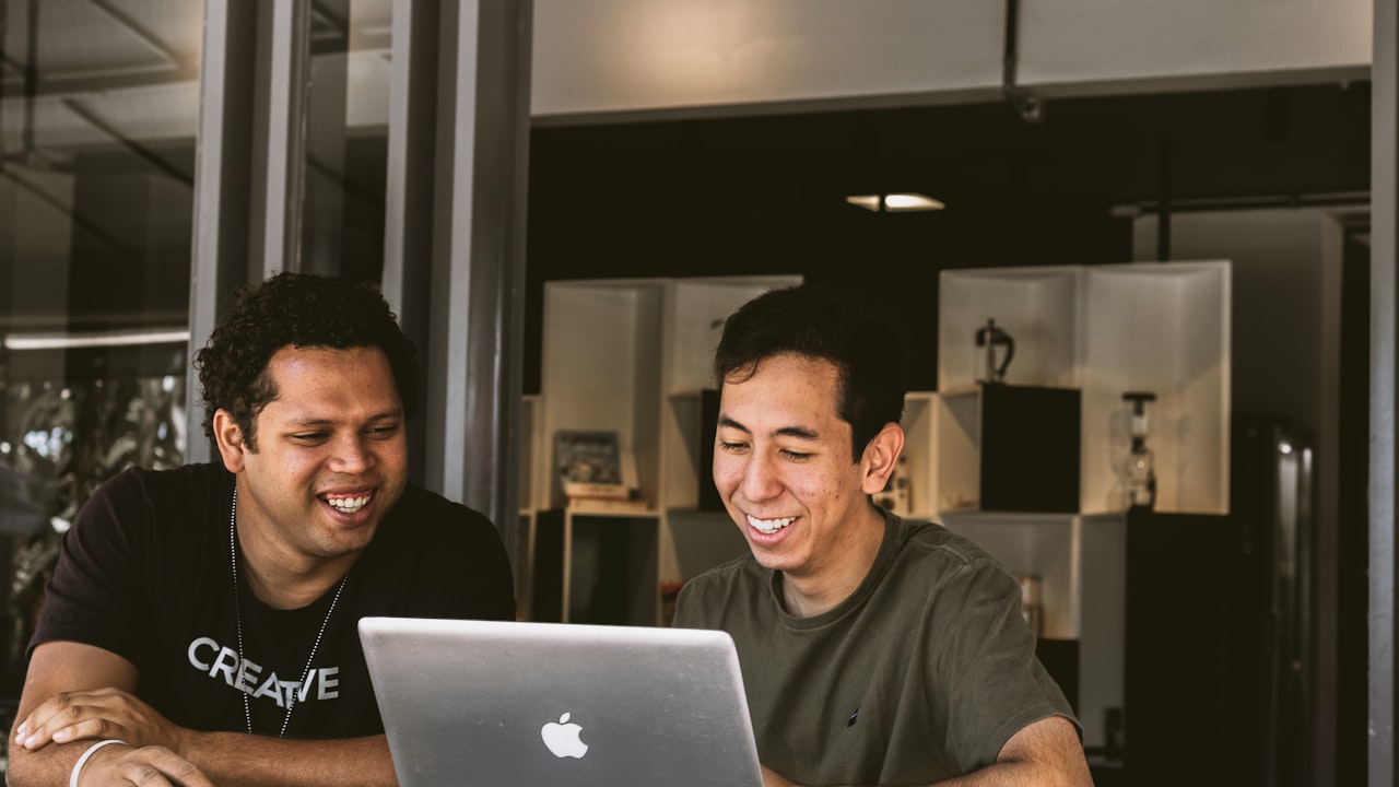 Equipo mirando una pantalla y sonriendo, conformes con el resultado